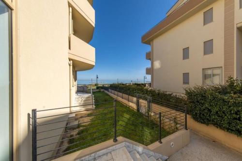 a balcony with a railing next to a building at Beachfront Luxurious Newly Built 2-Bed Flat with Stunning Sea Views & Terrace in Roseto degli Abruzzi