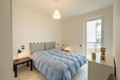 a large bed with a blue blanket in a bedroom at Beachfront Luxurious Newly Built 2-Bed Flat with Stunning Sea Views & Terrace in Roseto degli Abruzzi
