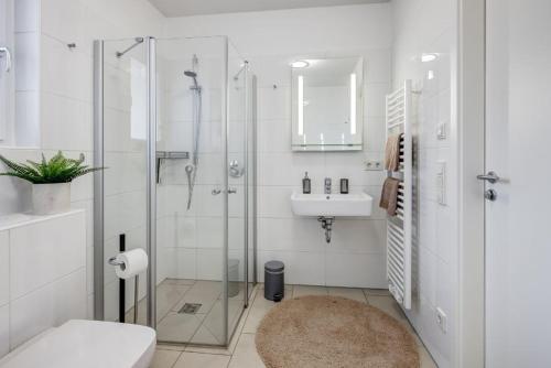 uma casa de banho com um chuveiro, um WC e um lavatório. em Exklusive Familienappartments Zugspitze em Garmisch-Partenkirchen