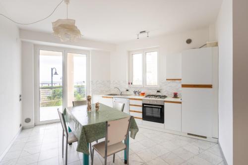 uma cozinha branca com mesa e cadeiras em Beachfront Luxurious Newly Built 2-Bed Flat with Stunning Sea Views & Terrace em Roseto degli Abruzzi