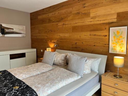 1 dormitorio con 1 cama y pared de madera en Exklusive Familienappartments Zugspitze, en Garmisch-Partenkirchen