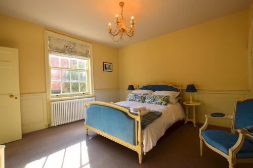 a bedroom with a bed and two blue chairs at 14 St Saviours Place, YORK in York