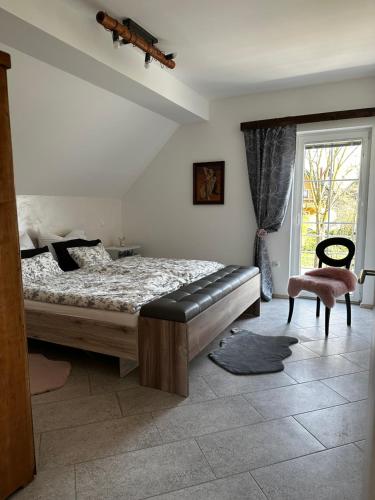 1 dormitorio con 1 cama, 1 silla y 1 ventana en Hiša Srečo, en Begunje na Gorenjskem
