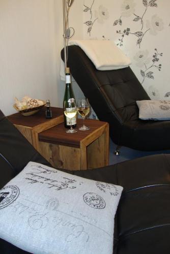 a living room with a bottle of wine and a table at Weingut Pension Gibbert-Pohl in Briedel