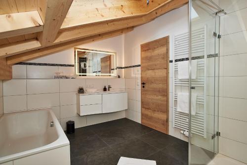 ein Badezimmer mit einer Dusche, einem Waschbecken und einer Badewanne in der Unterkunft Krennlehen in Schönau am Königssee