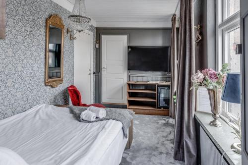 a small bedroom with a bed and a tv at Cameo Boutique Hotell in Ystad
