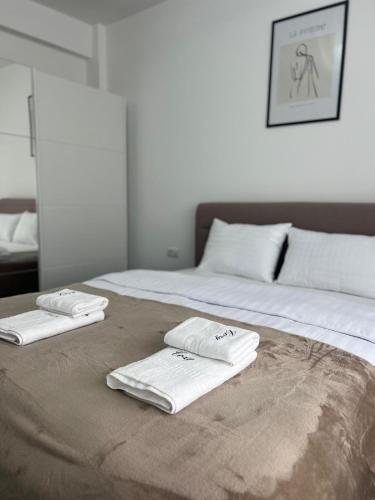 two white towels sitting on top of a bed at Marvellous Aparthotel with Master Apartments Suceava in Suceava