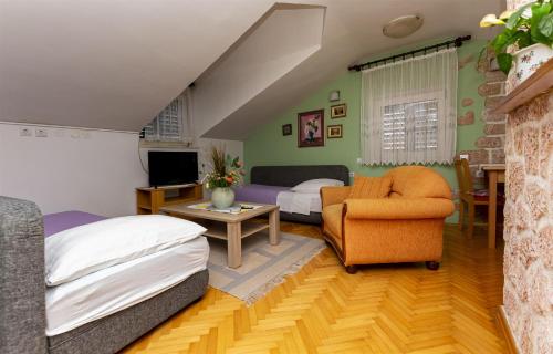 a bedroom with a bed and a couch and a chair at Apartment Ivanka in Omiš