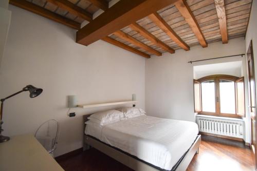 a bedroom with a bed and a desk and a window at Cora Aparthotel Stradivari in CastellʼArquato