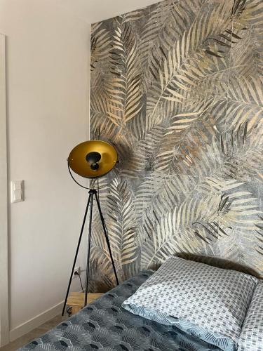 a bedroom with a bed with a feather patterned wall at Famaméro in Sanary-sur-Mer