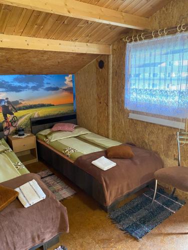 a bedroom with two beds and a painting on the wall at POKOJE GOŚCINNE RENATA KNITTER in Komnino