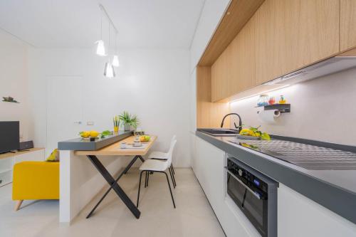 a kitchen with a counter and a table with a yellow chair at Casa Àura - Amalfi Coast in Maiori