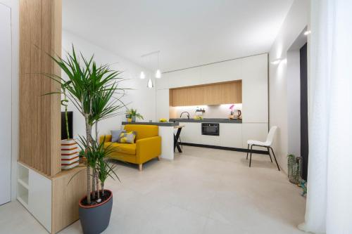 a living room with a yellow couch and a kitchen at Casa Àura - Amalfi Coast in Maiori