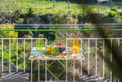 a table with a bowl of fruit and two glasses at Casa Àura - Amalfi Coast in Maiori