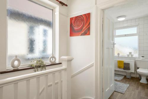 ein Bad mit einem WC und einem Fenster in der Unterkunft Home at The Brent in Dartford