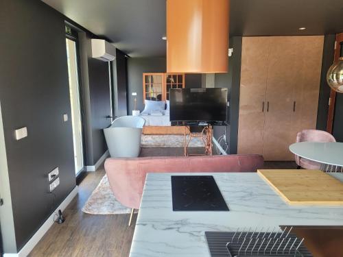 a living room with a pink couch and a tv at INFINITY HOUSES in Ponte da Barca
