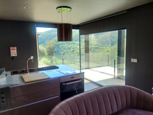 a kitchen with a counter and a large window at INFINITY HOUSES in Ponte da Barca