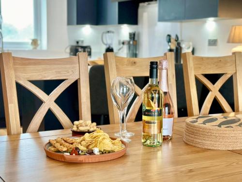 a bottle of wine and a plate of food on a table at South Beach Villa in Bridlington