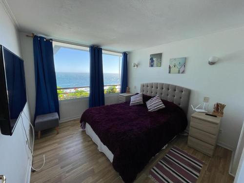 a bedroom with a bed and a large window at VADIGI COCHOA in Viña del Mar