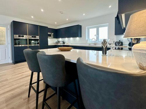 a kitchen with blue cabinets and a table and chairs at South Beach Villa in Bridlington