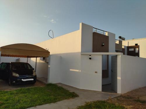 Maison de Noé Djerba Midoun في ميدون: سيارة متوقفة في موقف بجوار منزل