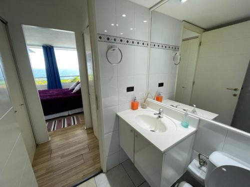 a white bathroom with a sink and a mirror at VADIGI COCHOA in Viña del Mar