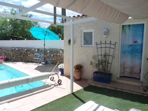 un patio avec une piscine et un parasol dans l'établissement La GARRIGUE, à Draguignan