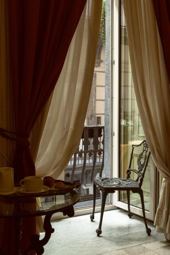 a chair and a table in a room with a window at Carafa di Maddaloni Residenza di Charme in Naples