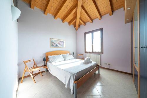サン・フェリーチェ・デル・ベナーコにあるAppartamento Antica Corteのベッドルーム1室(ベッド1台、椅子付)
