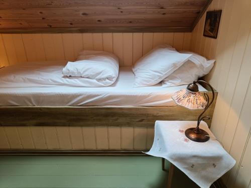 a bed in a room with a lamp on a table at Orheimstunet - Gårdsferie for storfamilien der også hunden er velkommen in Orheim