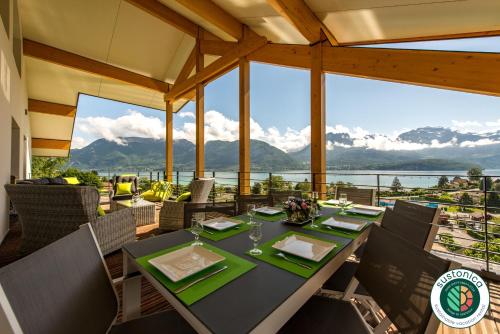 a dining room with a table and views of the mountains at Le Panoramic - Loft & Mainfloor Outstanding lake View - LLA Selections by Location lac Annecy in Sévrier