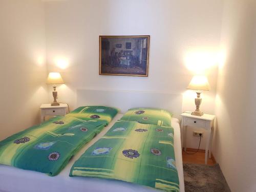 オストゼーバート・ゼリンにある2 Raumwohnung mit sonniger Terrasse und Seeblickのベッドルーム(ベッド2台、緑の掛け布団付)