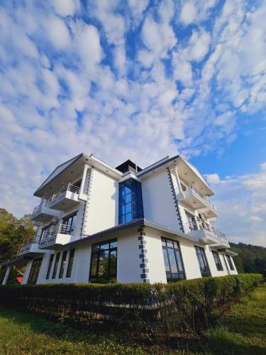 ナガルコットにあるHotell Hill Crownの青い窓のある大きな白い建物