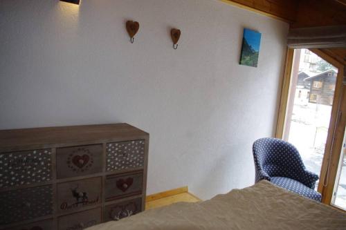 a bedroom with a dresser and a bed and a window at Forum L au centre de Zinal in Zinal