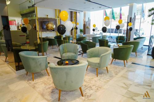 a room with green chairs and balloons on the wall at AKASIYA HOTEL in Doha