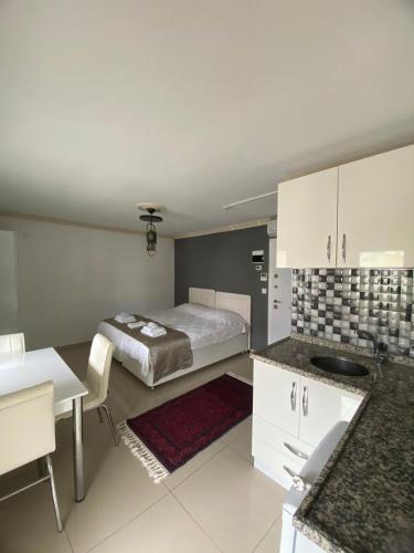 a bedroom with a bed and a kitchen with a table at Erbay Mansions Hotel in Trabzon