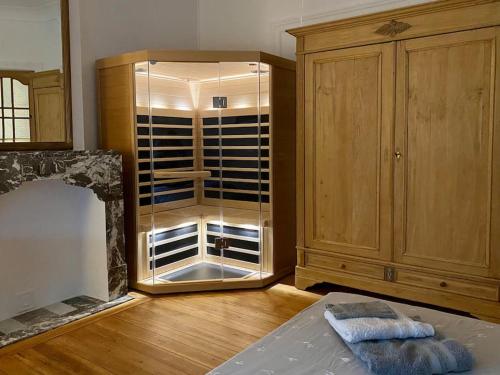 Zimmer mit einem Glasschrank und einem Kamin in der Unterkunft Les Valcaprimontoises … en ville ! in Lüttich