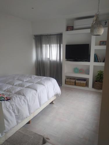 een slaapkamer met een bed en een flatscreen-tv bij Departamento en Tandil x 2 in Tandil