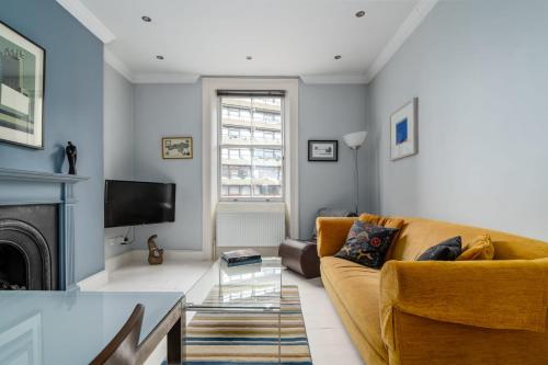 a living room with a couch and a fireplace at 2bed 2bath Victorian maisonette in Barbican in London