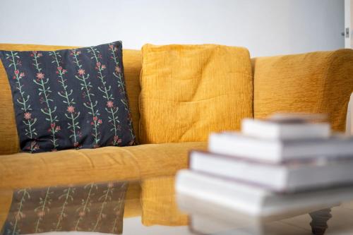 una pila de libros en una mesa junto a un sofá en 2bed 2bath Victorian maisonette in Barbican en Londres