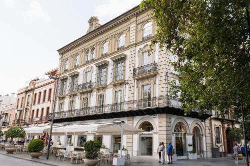塞维利亚Hotel Tayko Sevilla的一座大楼，前面有人走动
