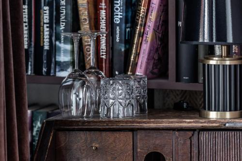 two glasses and a lamp on a book shelf at Cameo Boutique Hotell in Ystad