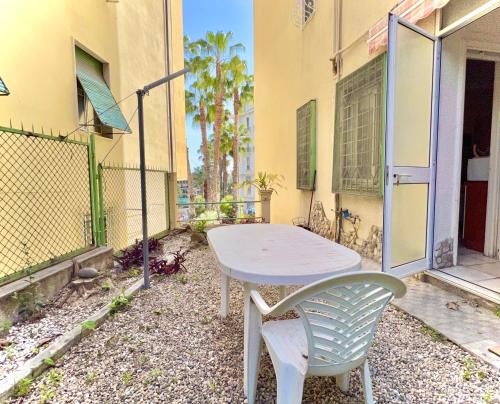 une table et une chaise assises à l'extérieur d'un bâtiment dans l'établissement WH - Trilocale Duca a due passi dalla stazione dei treni, à Sanremo