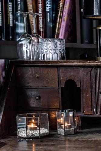 two candles on a wooden table with books at Cameo Boutique Hotell in Ystad