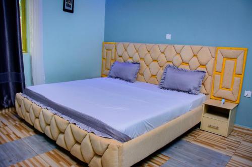 a large bed in a room with a blue wall at IREBERO DREAM HOME in Kayonza