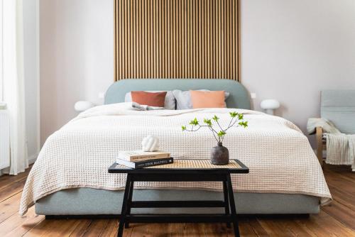 a bedroom with a blue bed with a table at HORAMI Villa - OKYU Apartment in Malchow