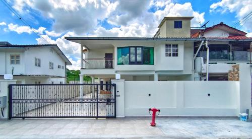 una casa con una valla blanca y una boca de incendios roja en JB City Villa (Private Pool) en Johor Bahru