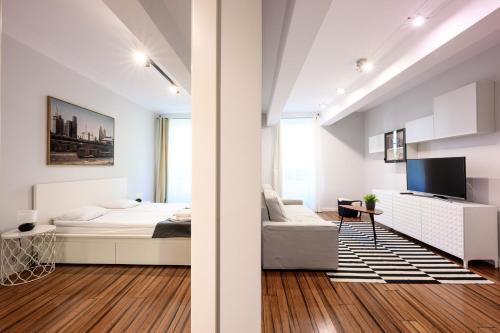 a white bedroom with a bed and a tv at Premium Apartments by Wawel Castle in Krakow