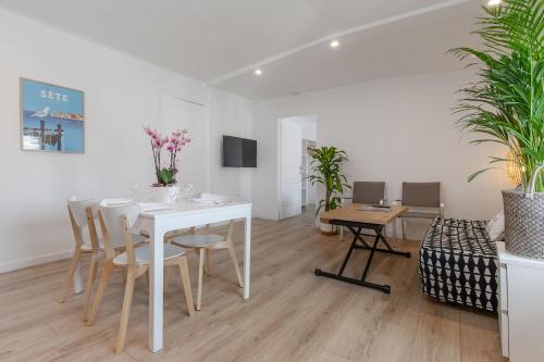 une salle à manger blanche avec une table et des chaises blanches dans l'établissement Flamingo Center Clemenceau, à Béziers