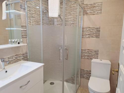 a bathroom with a shower and a toilet and a sink at NOCTUA PARAISO ALTO 011 in Estepona